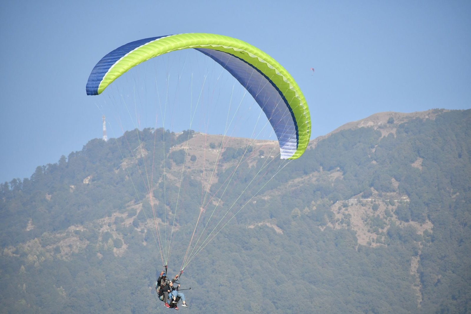 Thrilling paragliding over Bir's lush landscapes on a clear day.