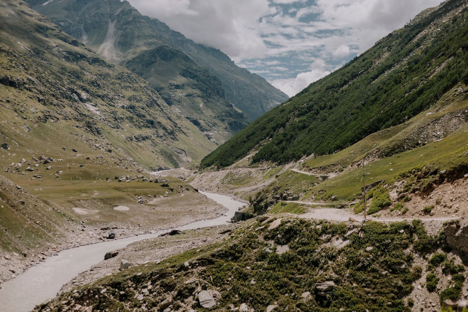 Breathtaking view of a remote valley in Himachal Pradesh, showcasing rugged mountains and lush greenery.