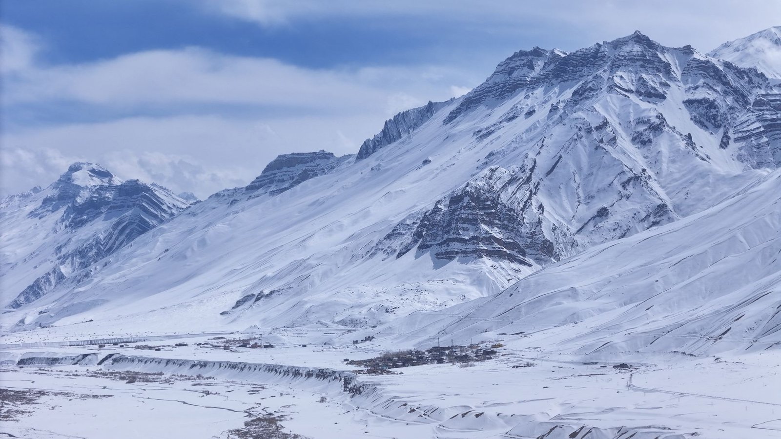 Panoramic view of snow-laden peaks in Spiti Valley, showcasing winter beauty.