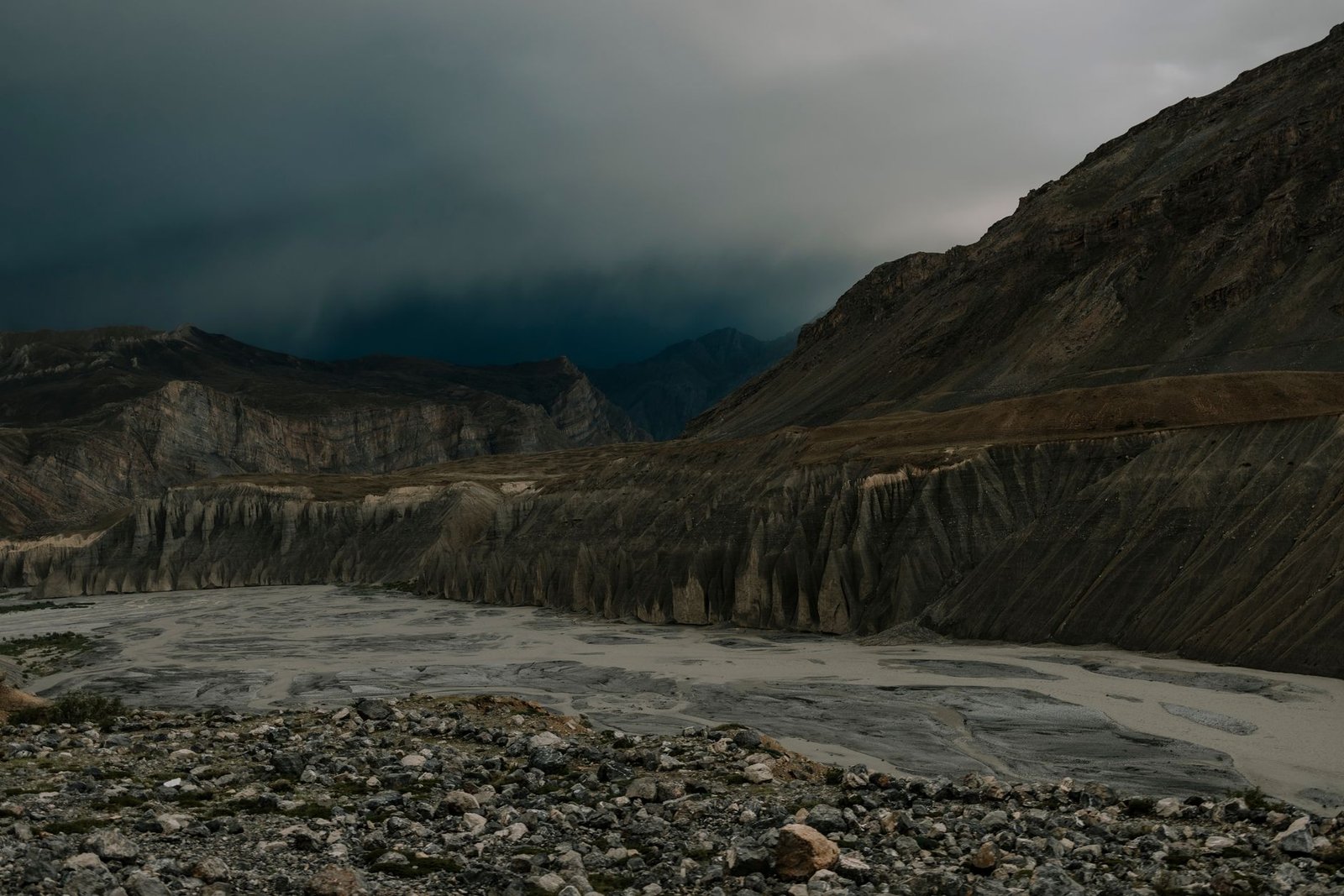 View of Spiti Valley with dramatic clouds and rugged mountains creating a moody scene.