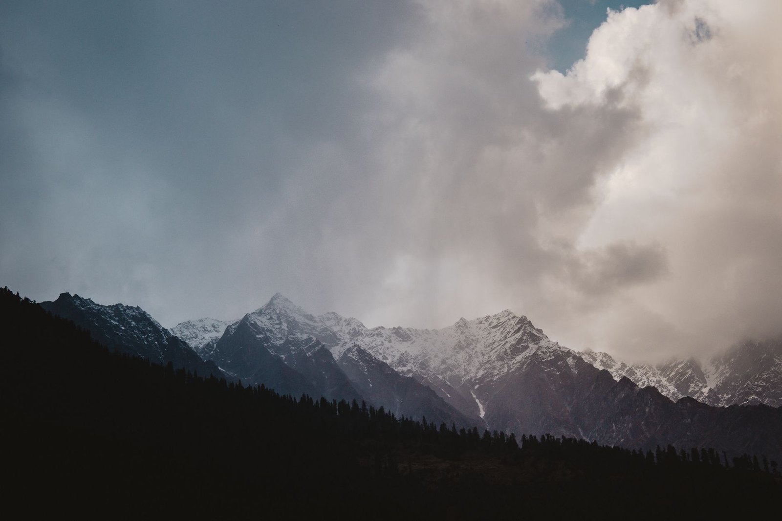 A majestic view of Himalayan mountains with dramatic clouds in Shimla, India.