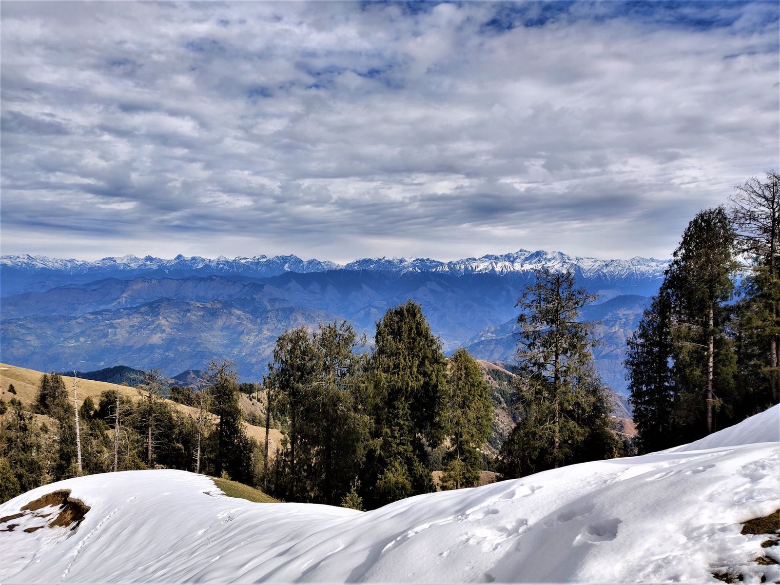 Breathtaking view of snow-covered Himalayas in winter from Rakhed, Himachal Pradesh, India.