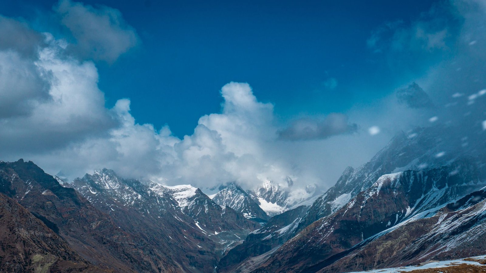 Explore the breathtaking view of snow-capped peaks under a vivid blue sky, perfect for travel and nature enthusiasts.