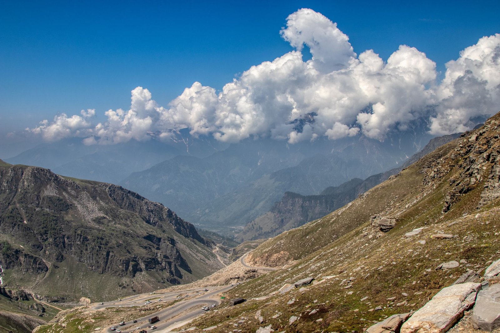 Stunning view of mountains and valleys in Manali, India, under a vivid blue sky with clouds.