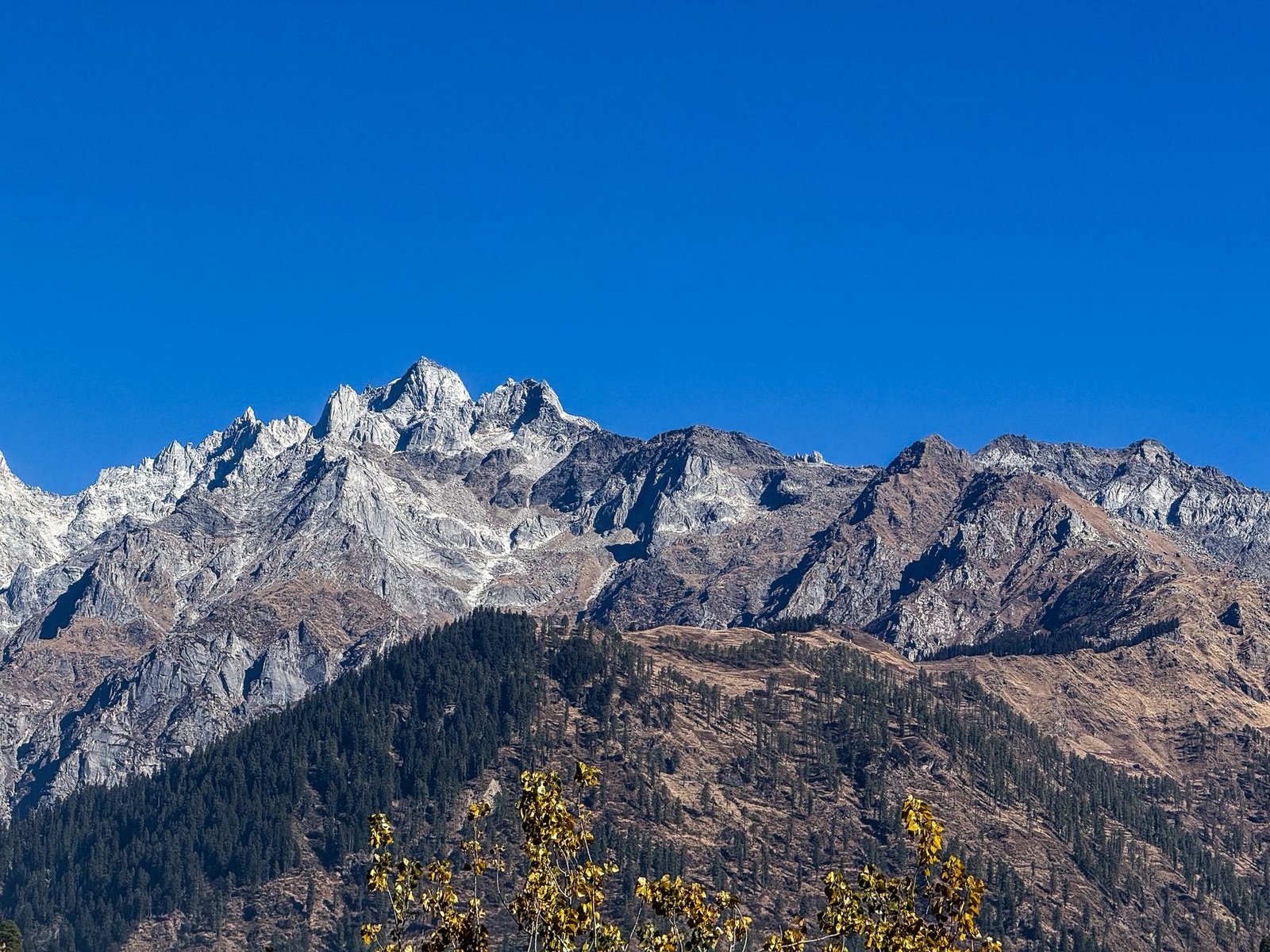 Stunning view of the rugged mountains under a clear blue sky in Kasol, Himachal Pradesh.