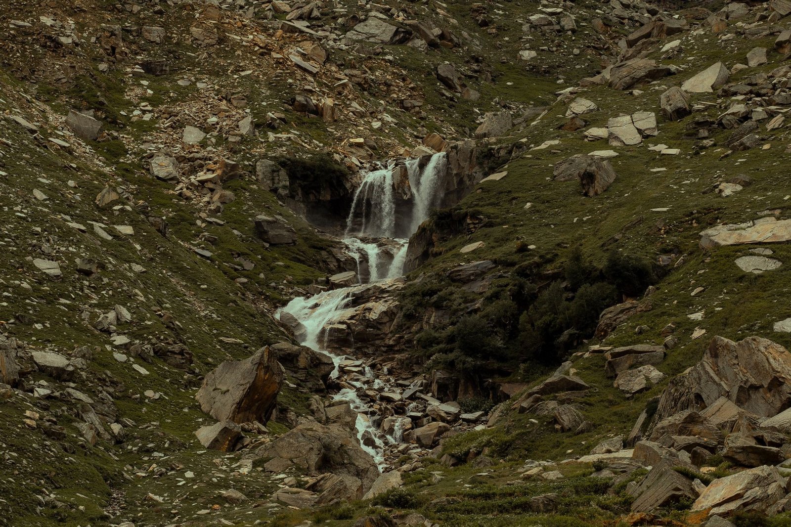 Beautiful waterfall flowing through rocky Himalayan terrain in Himachal Pradesh, India.