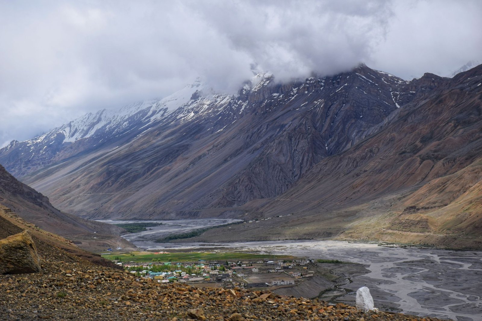 Breathtaking view of a Himalayan valley with snow-capped mountains and a winding river.