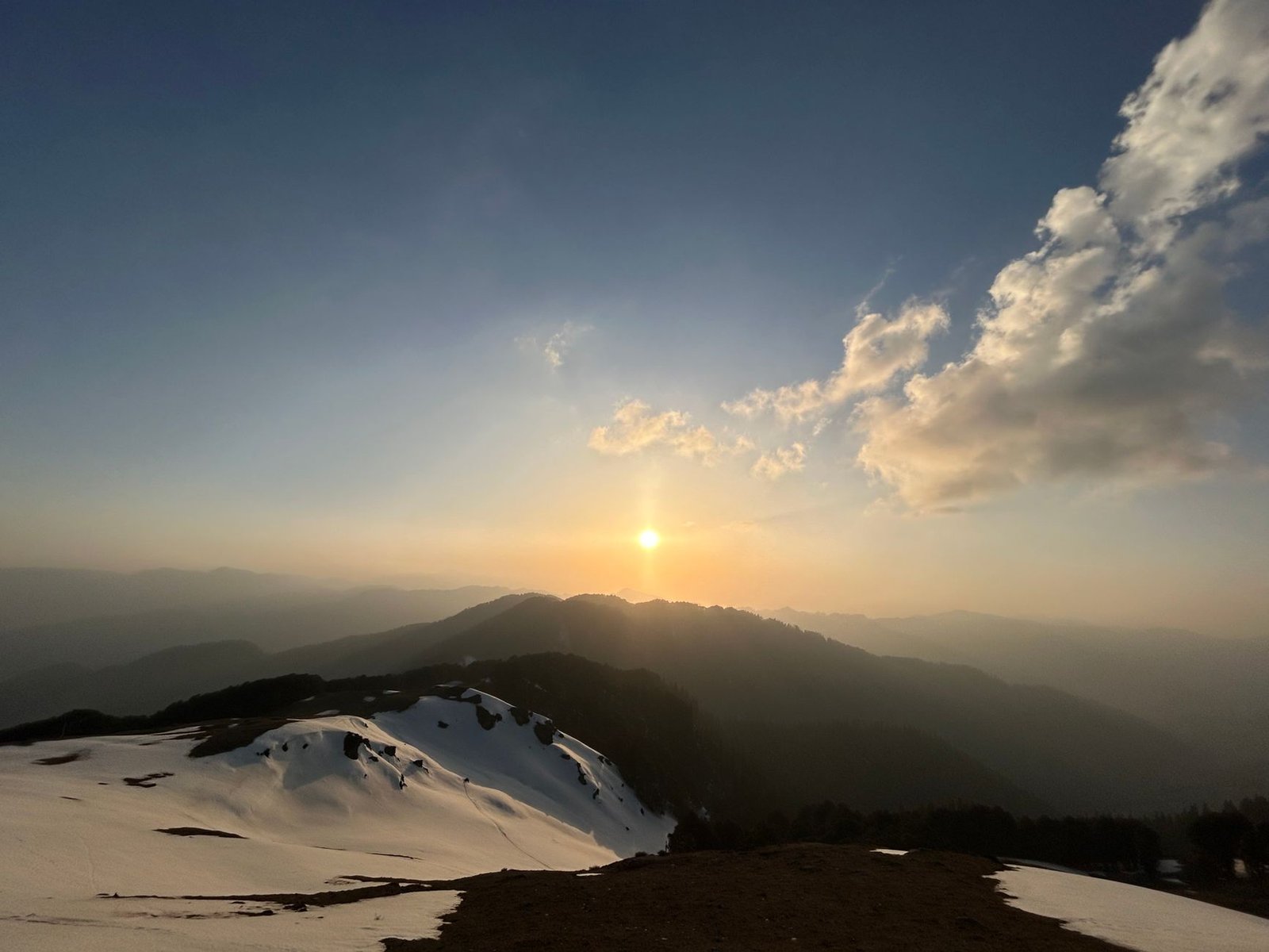Captivating sunset view over snow-covered mountains in Jibhi, Himachal Pradesh.