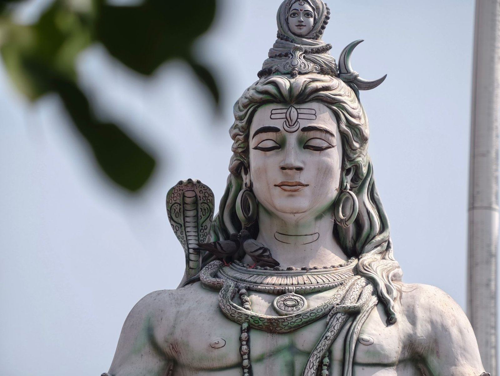 Close-up of a large statue of Lord Shiva, showcasing intricate details and serene expression.