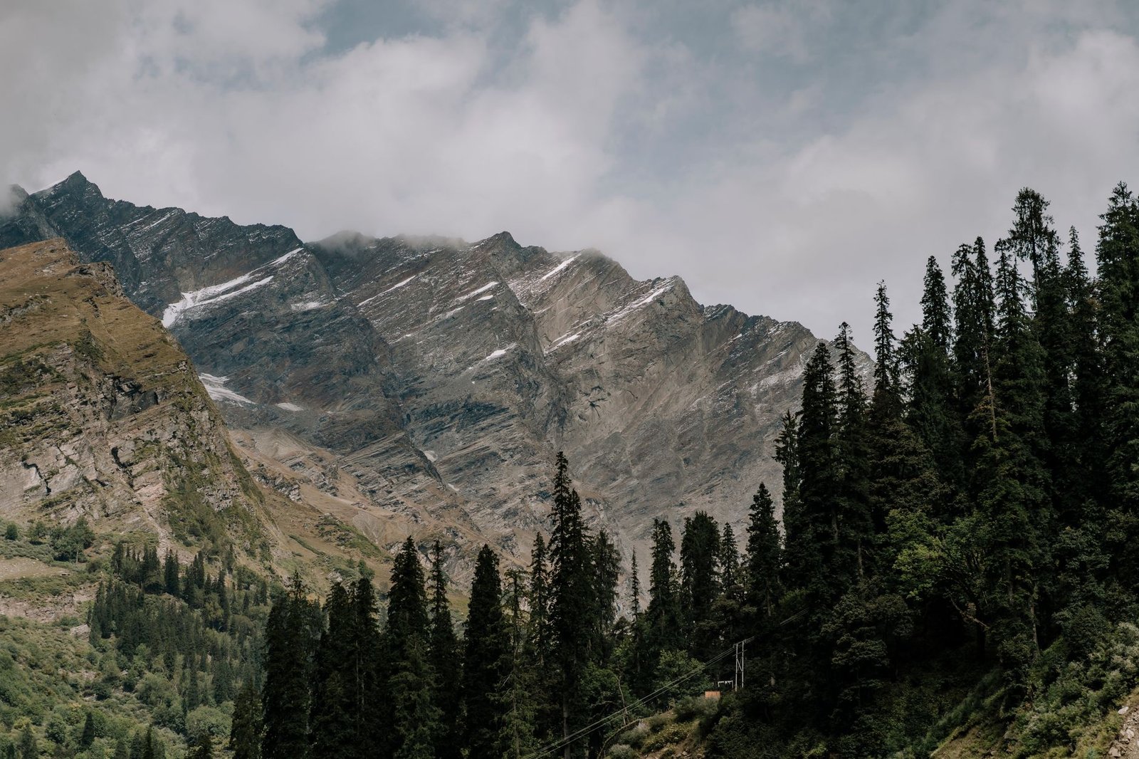 Scenic view of the Himalayan mountains with lush pine forests in Himachal Pradesh.