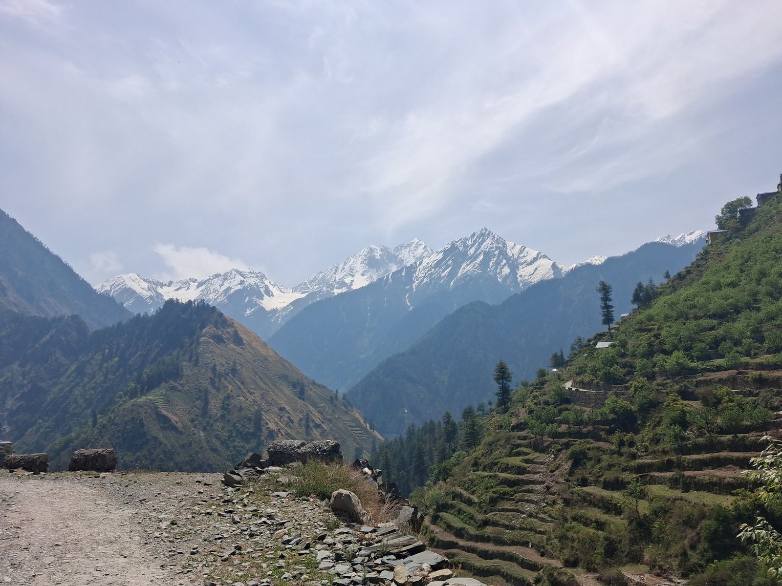 Stunning view of Himalayan mountains with snow peaks and terraced hillsides during spring.