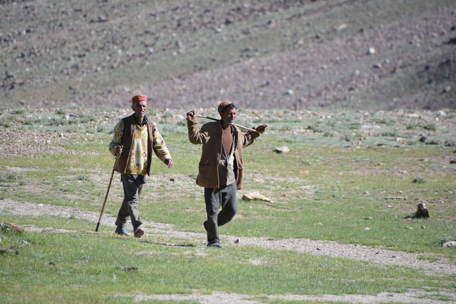 Two local men walking in the scenic landscape of Himachal Pradesh.